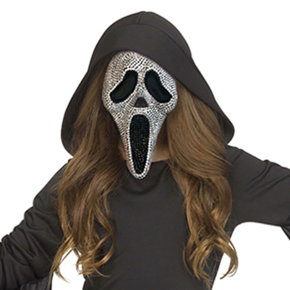 A person wearing a black hooded Ghostface-style costume mask covered in silver rhinestones, with long wavy brown hair and a black top, against a plain white background.