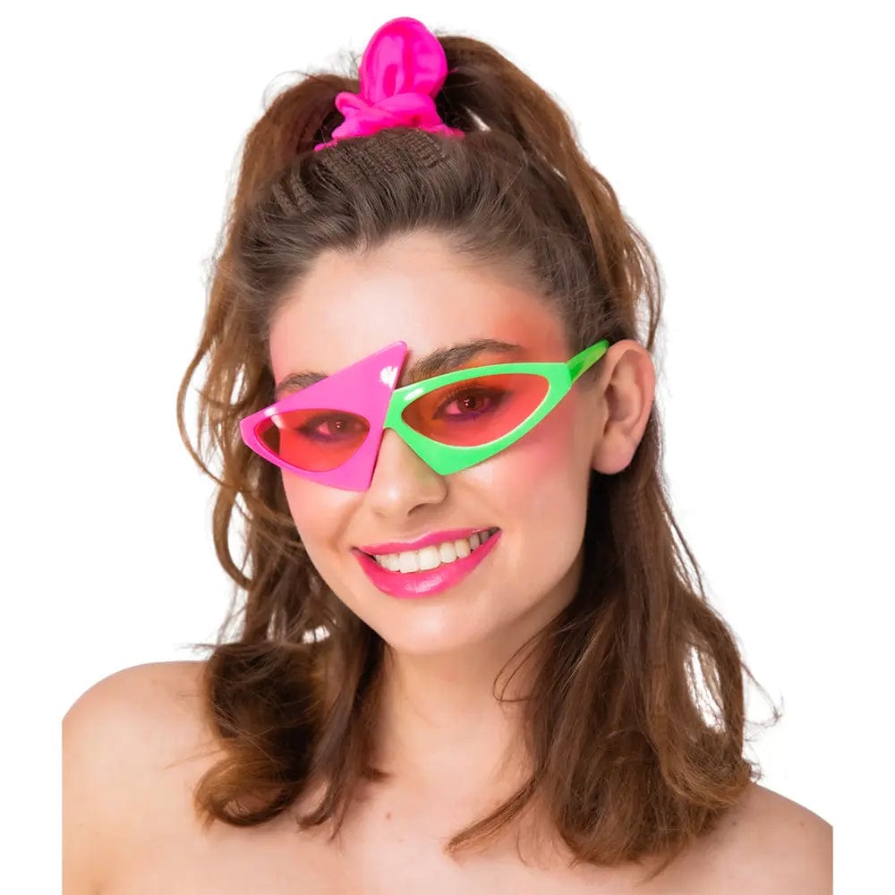 Model wearing bright neon pink and green zig zag style sunglasses for 1980s fancy dress costumes