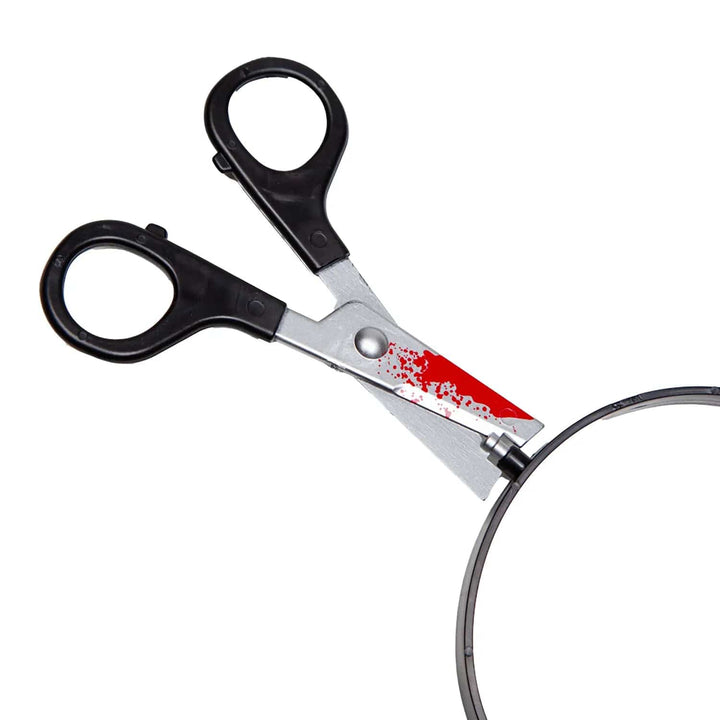 Close up of plastic scissors with blood spatter effect on a headband for Halloween fancy dress costumes