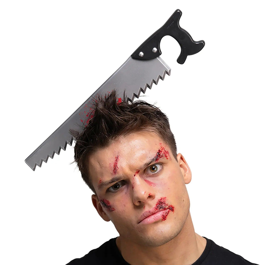 Man with zombie makeup and a bloody saw prop in his head fr Halloween fancy dress costumes