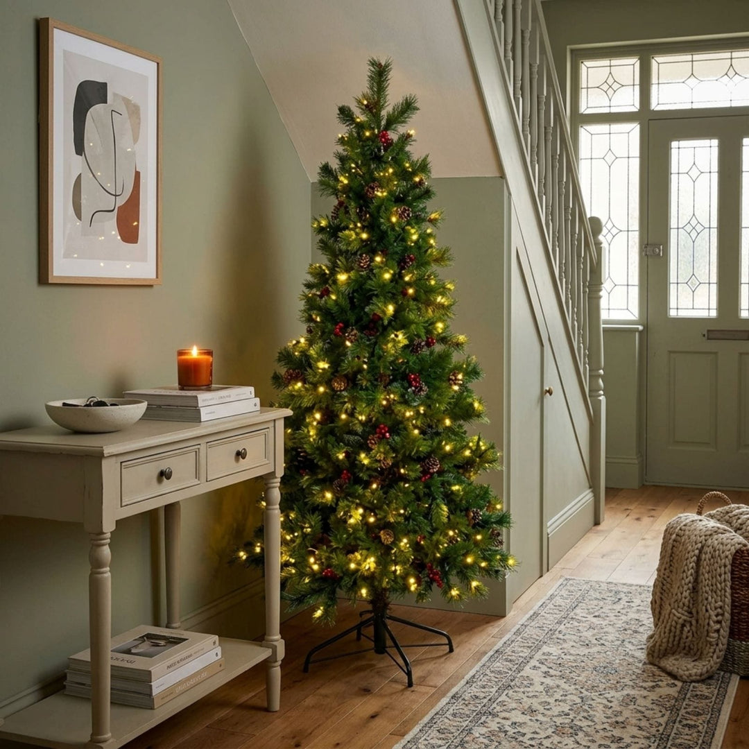 Decorated Christmas tree in a room with a side table and staircase.