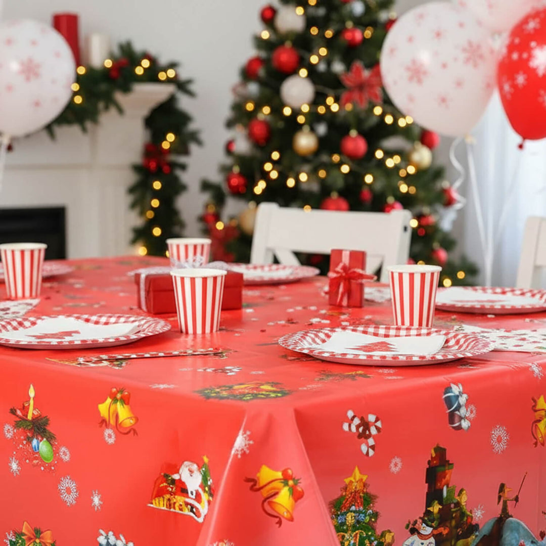 Christmas-themed table setting with red tablecloth, decorations, and balloons.