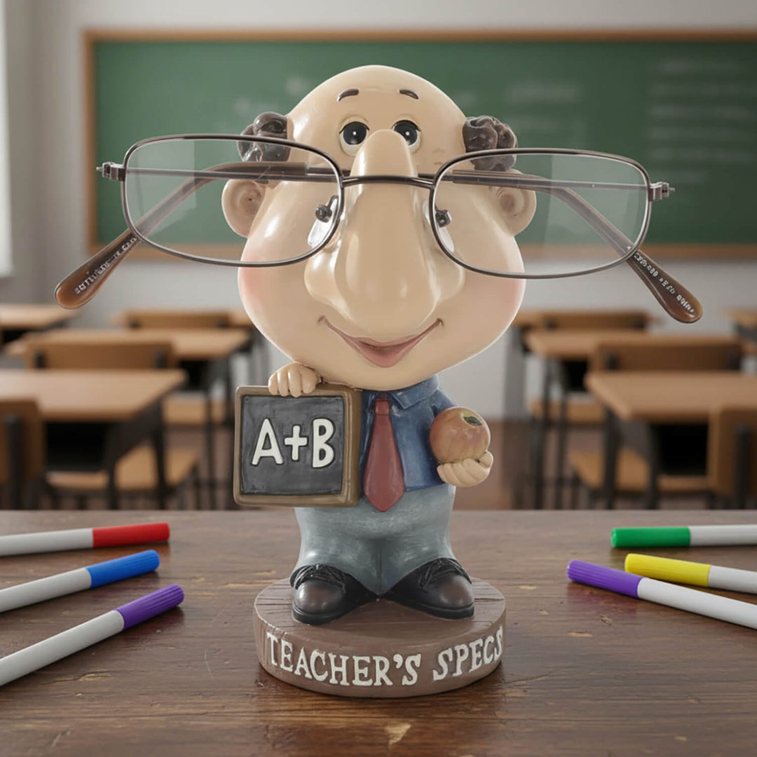 Novelty teacher figure reading glasses holder on a desk with and a chalkboard in a classroom setting
