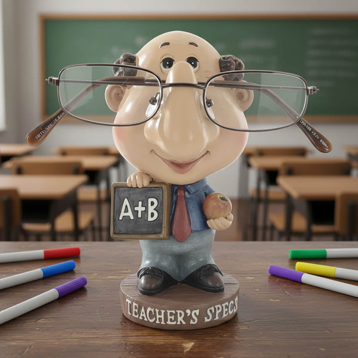 Novelty teacher figure reading glasses holder on a desk with and a chalkboard in a classroom setting