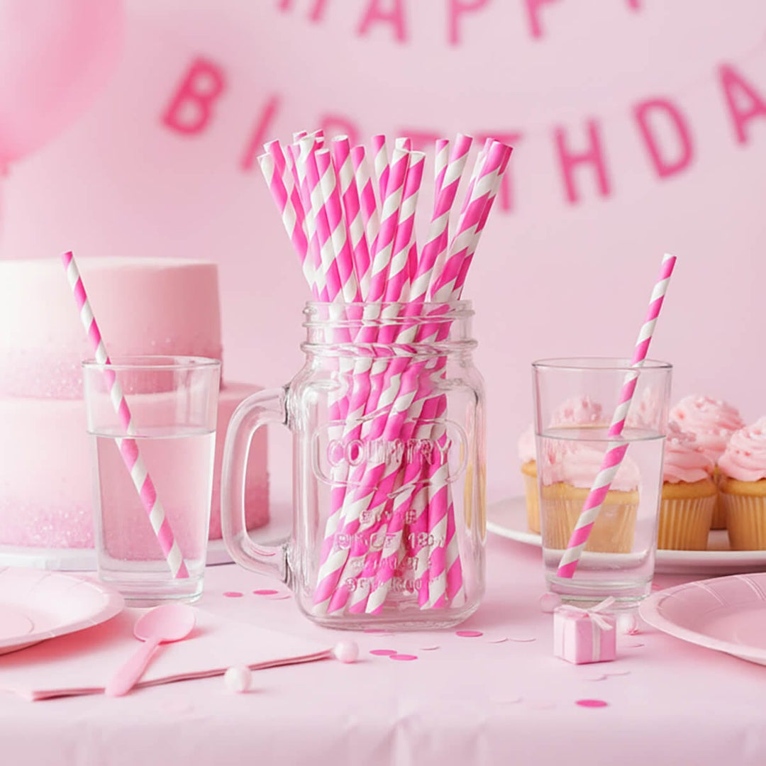 Glass jar full of pink and white straws on a pink theme birthday party table