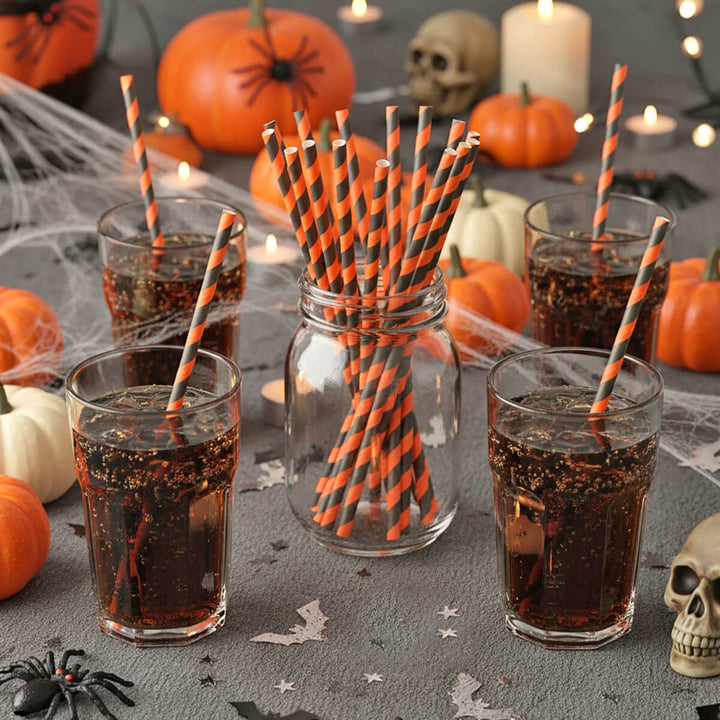 Halloween party table with cola drinks and orange and black striped straws