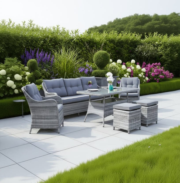 Outdoor patio set with gray cushions on a patio with greenery in the background