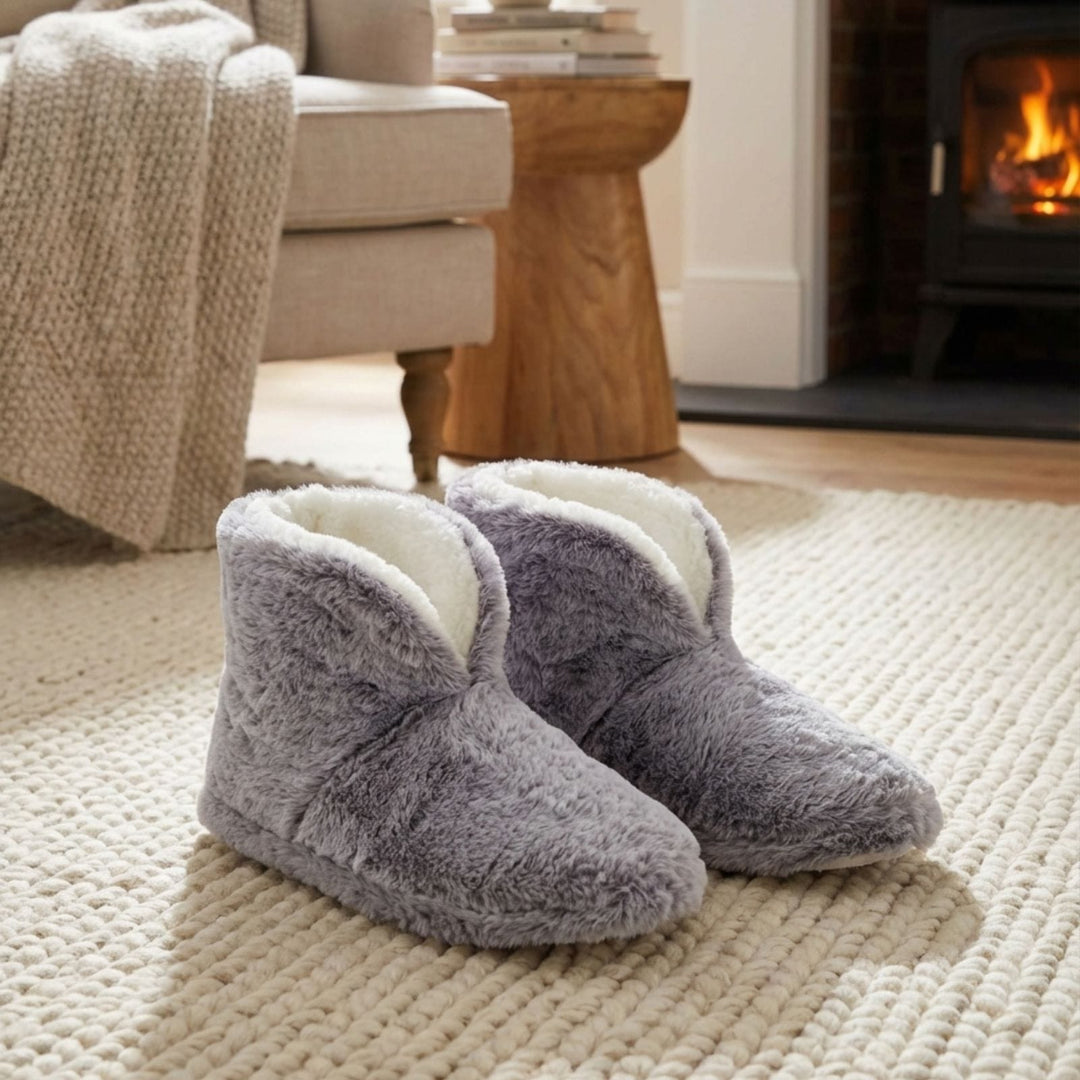 faux fur boot slippers on jute rug in living room with cosy fireplace in background