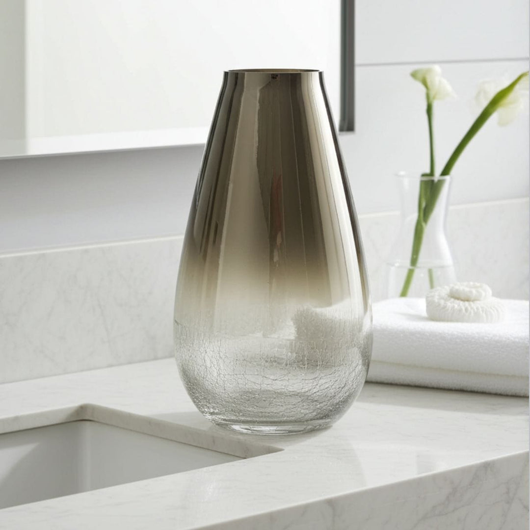 Smoky glass vase on a white surface with a blurred background