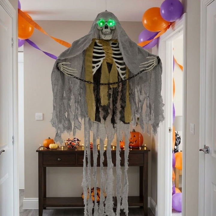 skeleton decoration hanging from ceiling in hallway with purple and orange balloons and consol table in background with candy and pumpkin