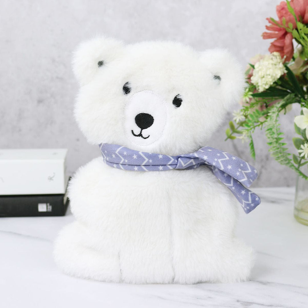 White teddy bear with a purple bow tie on a light gray surface with flowers in the background