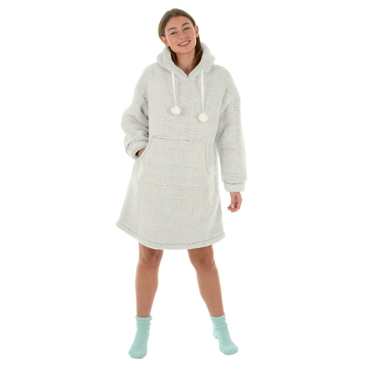 Female model wearing a light grey fleece hoodie with pom poms