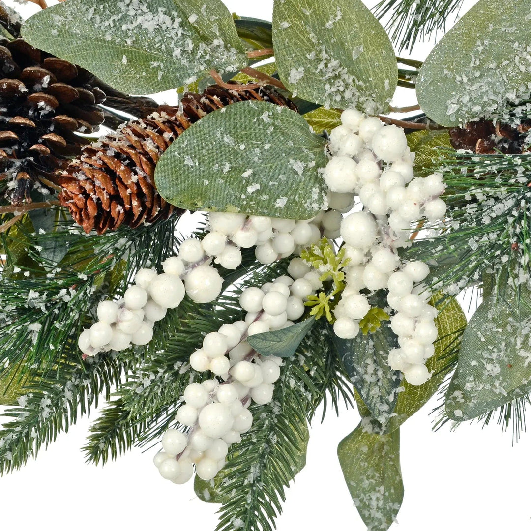 Large bunch of snowberries and pine cones on a green Christmas wreath