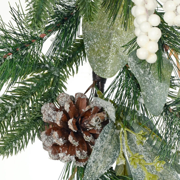 Close up of frosted pine cone and snow berries on an artificial Christmas garland