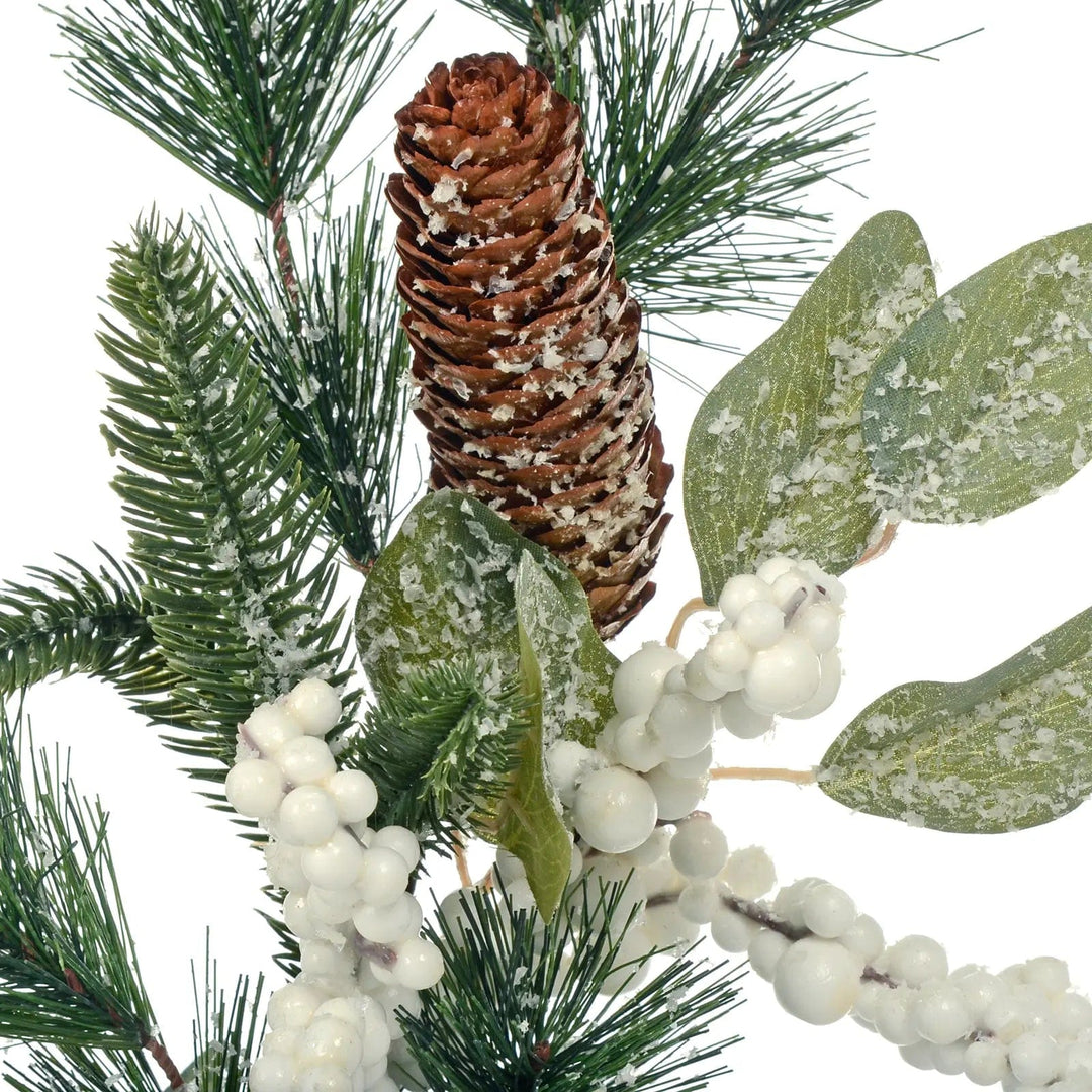 Large pine cone and snow berries with green spruce branches on a Christmas garland