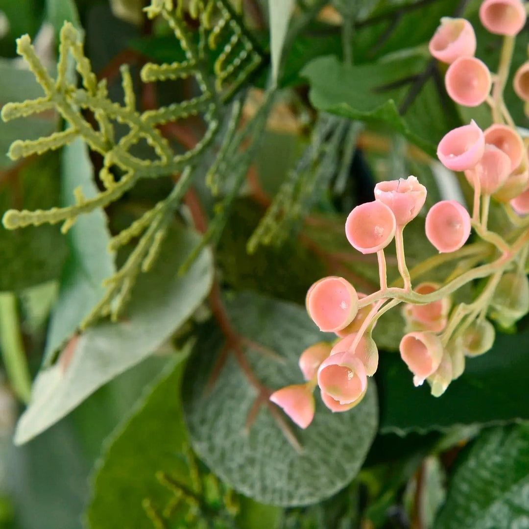 Close up of artificial pink flowers on a green leaf Christmas wreath