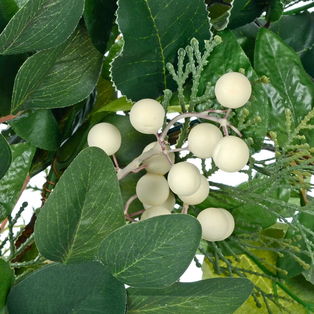 Close up of white snowberries and green fabric leaves on a seasonal festive wreath