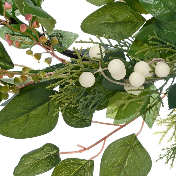 detail of white snow berries and pink flowers on an artificial Christmas garland