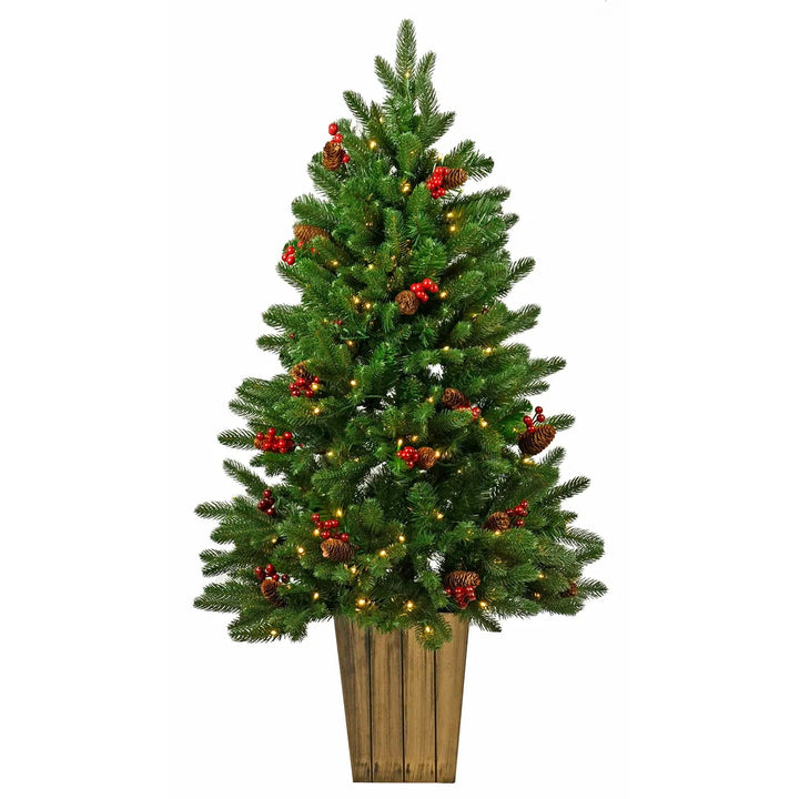 Green pine Christmas tree with pine cones, red berries, wood effect pot and warm white fairy lights