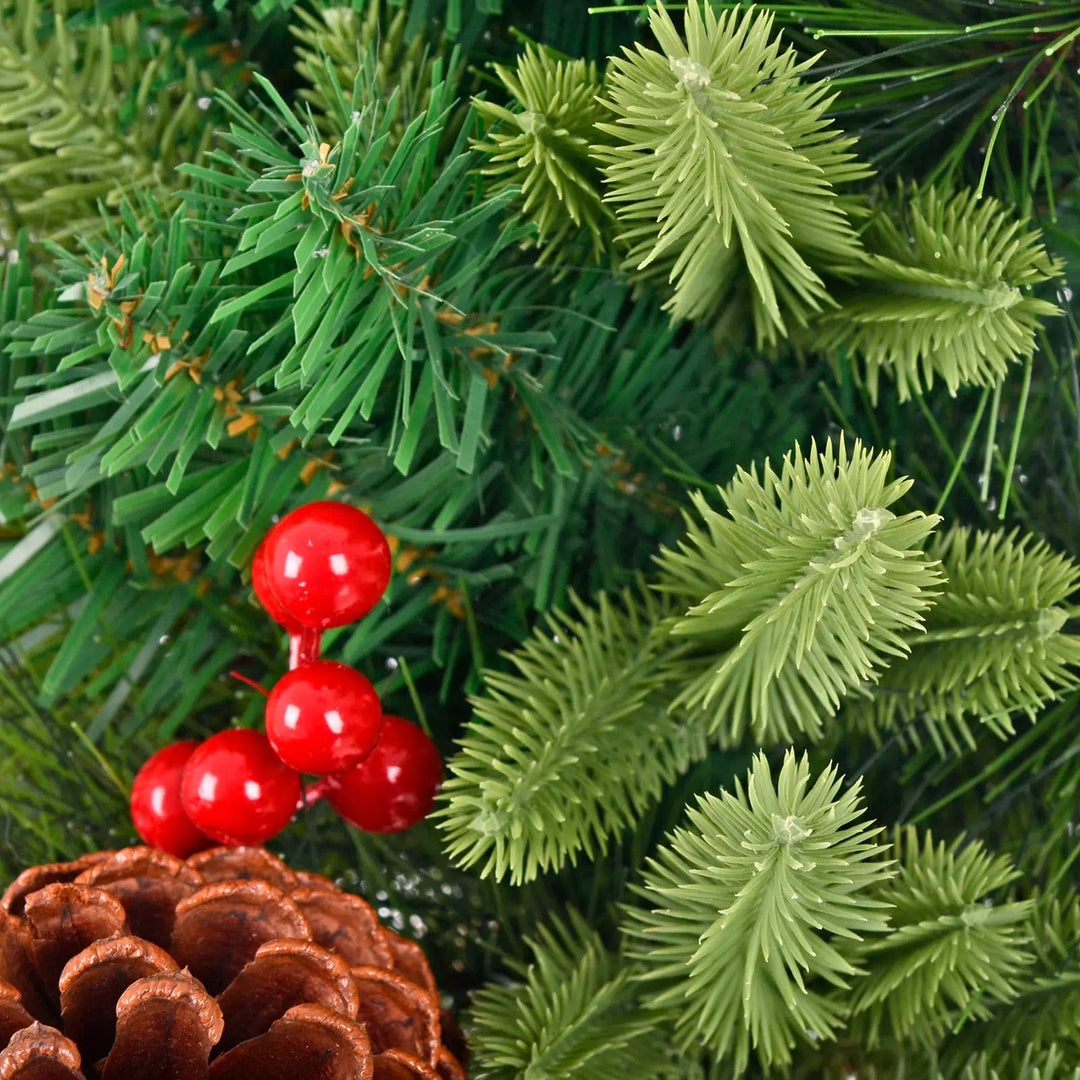 Close up of green pine branches, red berries on a Christmas tree