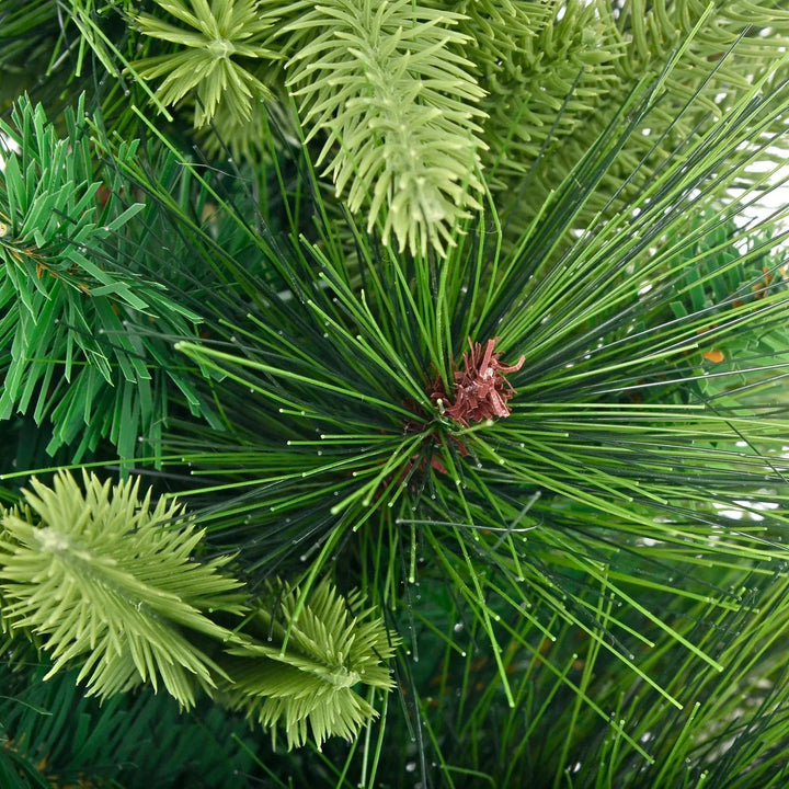 Close up of a green larch tip on a green mixed pine Christmas tree