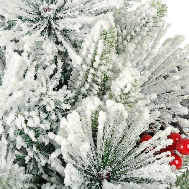 Close up of fake snow covered pine branches on a small Christmas tree