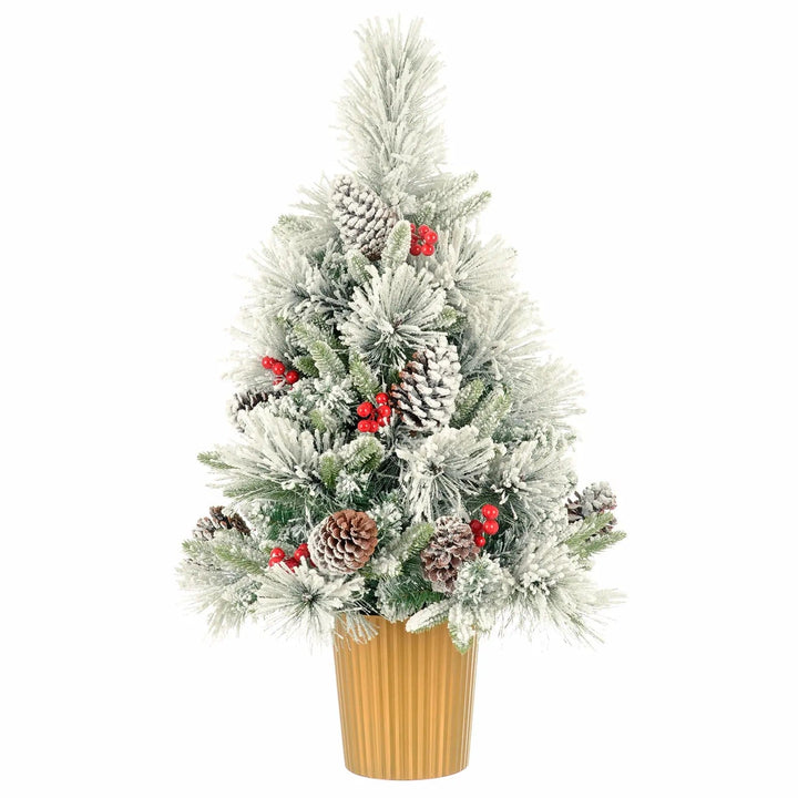 Artificial snow covered Christmas tree with pine cones, red berries in a gold coloured pot