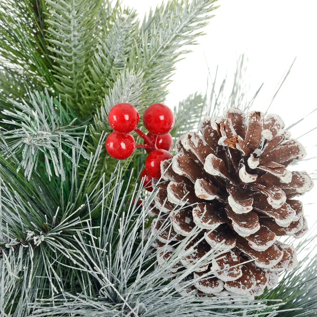 Detail of a frost covered pine cones and red berries on an artificial Christmas tree