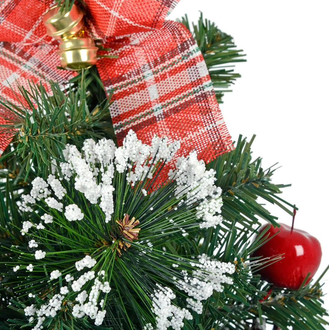 Christmas tree pine branch with white snow effect, red tartan ribbon and red apple