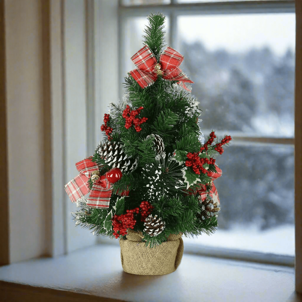 Small Christmas tree decorated with red tartan bows, gold bells, berries, holly and pine cones