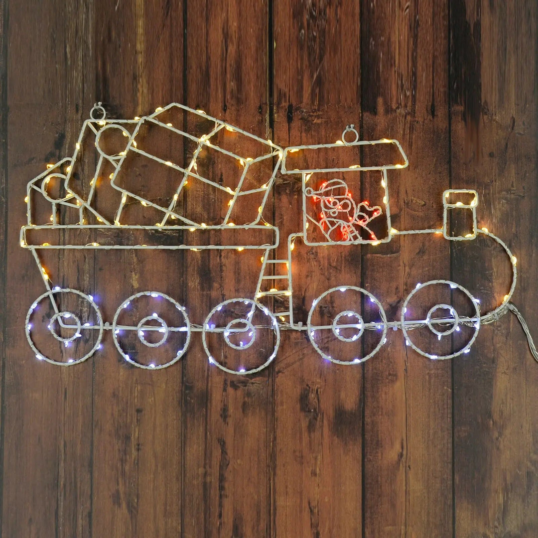 Santa in Train light up Christmas decoration with white and red LED lights hanging on a wooden fence