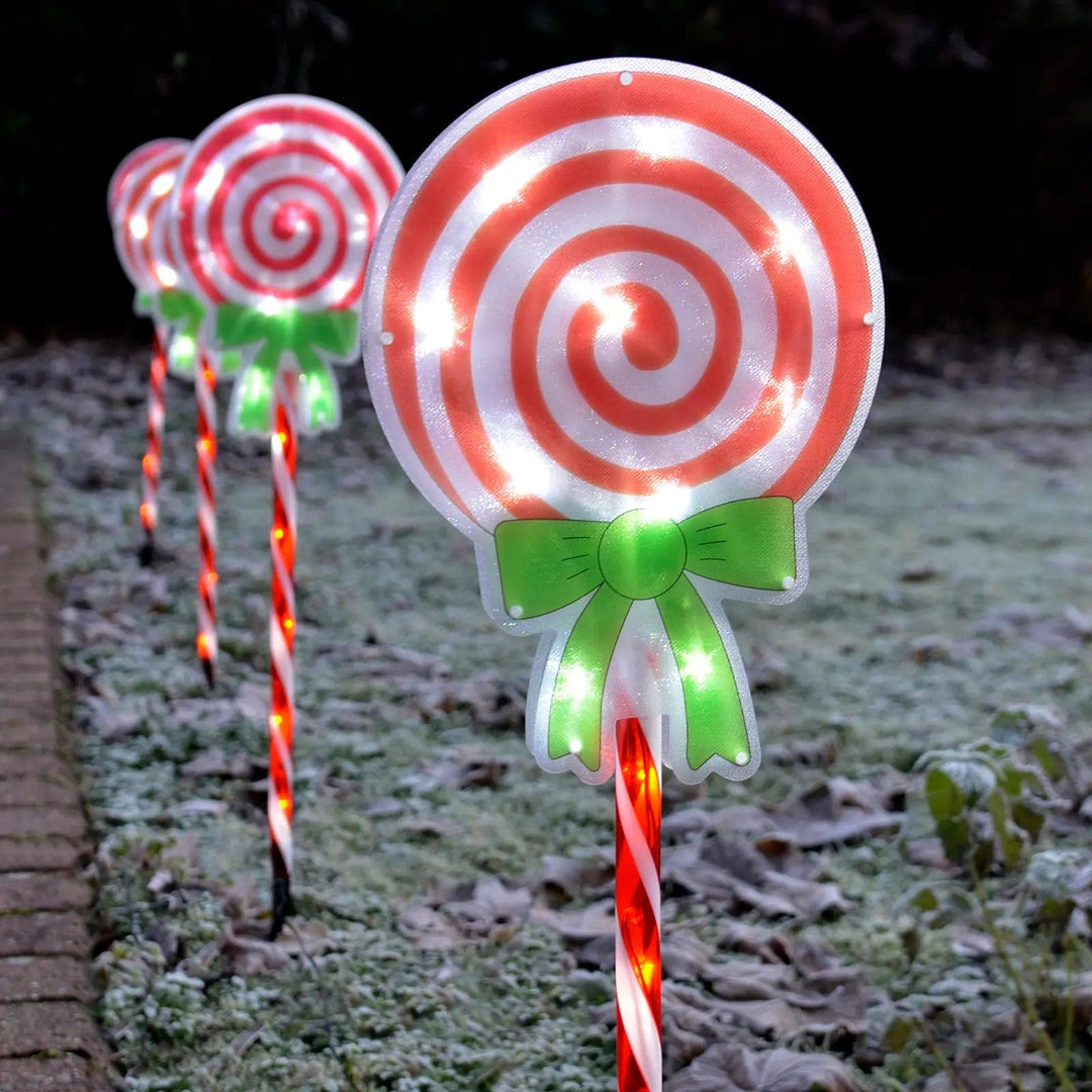 Christmas candy cane lollypop pathway lights on a frosty morning outdoors in a garden