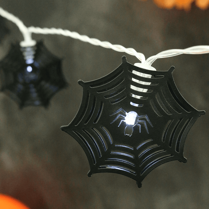 detail shot of black metal cobweb lights on black background with bright white led light