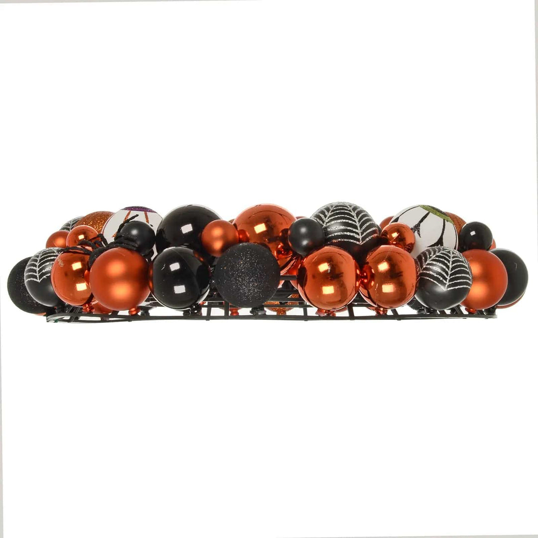 Side view profile of an orange and black bauble Halloween wreath decoration