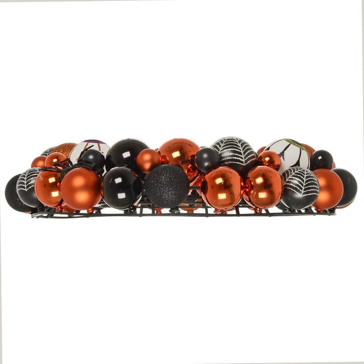 Side view profile of an orange and black bauble Halloween wreath decoration