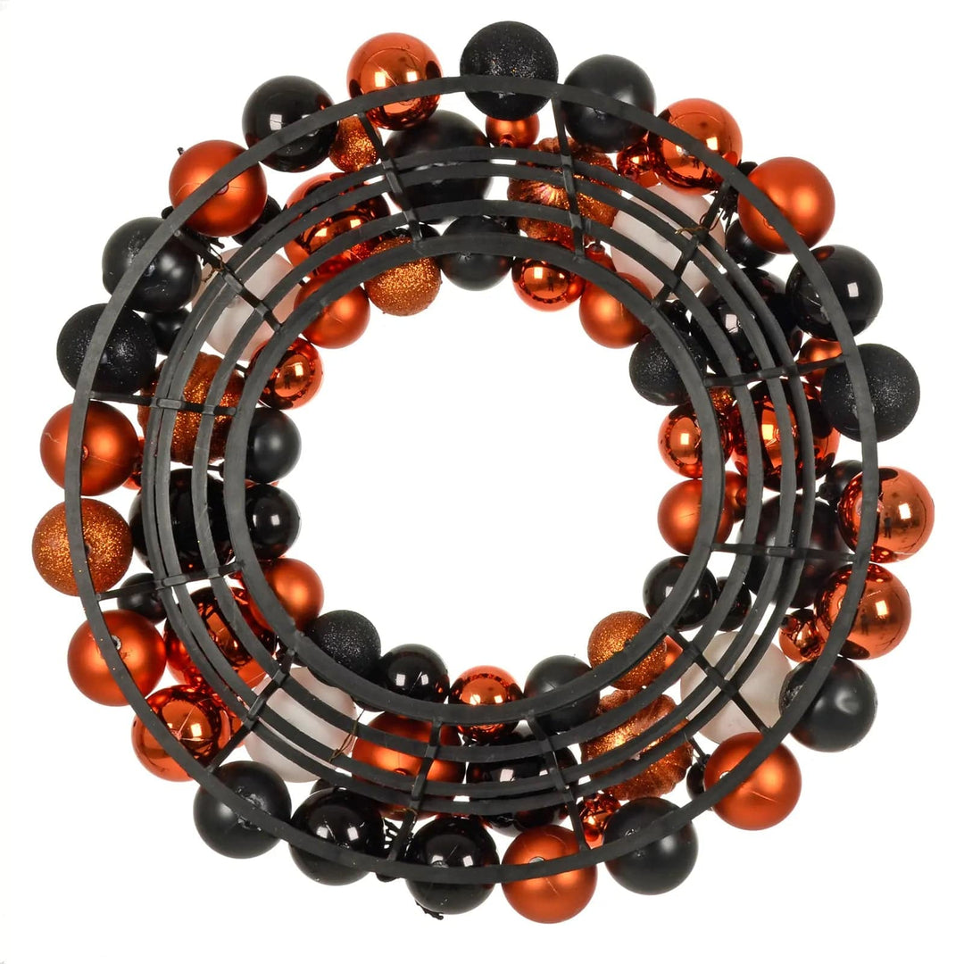 Back view of an orange and black bauble Halloween wreath decoration