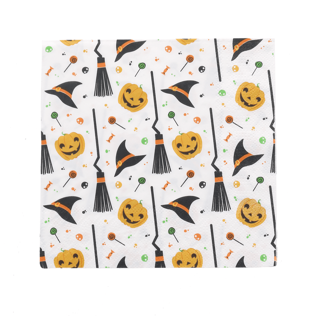 single halloween napkin featuring white background with orange and black pumpkins, witches hats, witches brooms, halloween candy and dots