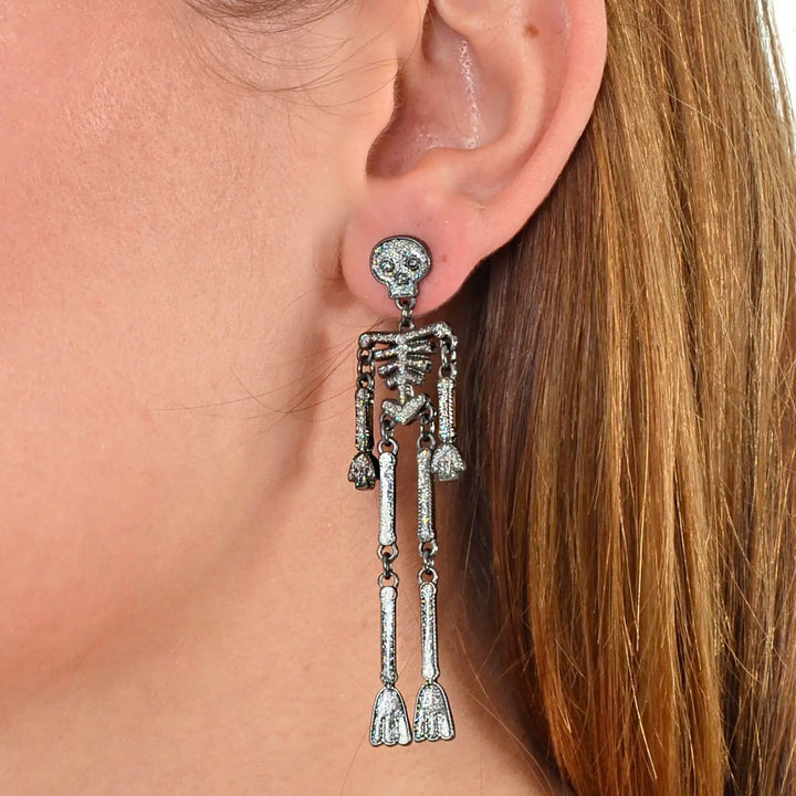 Long skeleton drop earrings with silver glitter and jointed limbs to move at Halloween parties