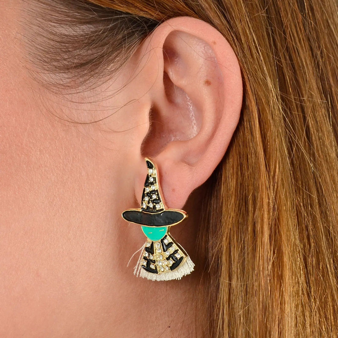 Model wearing witch stud earrings with green face and jewelled hat and cloak for Halloween costumes