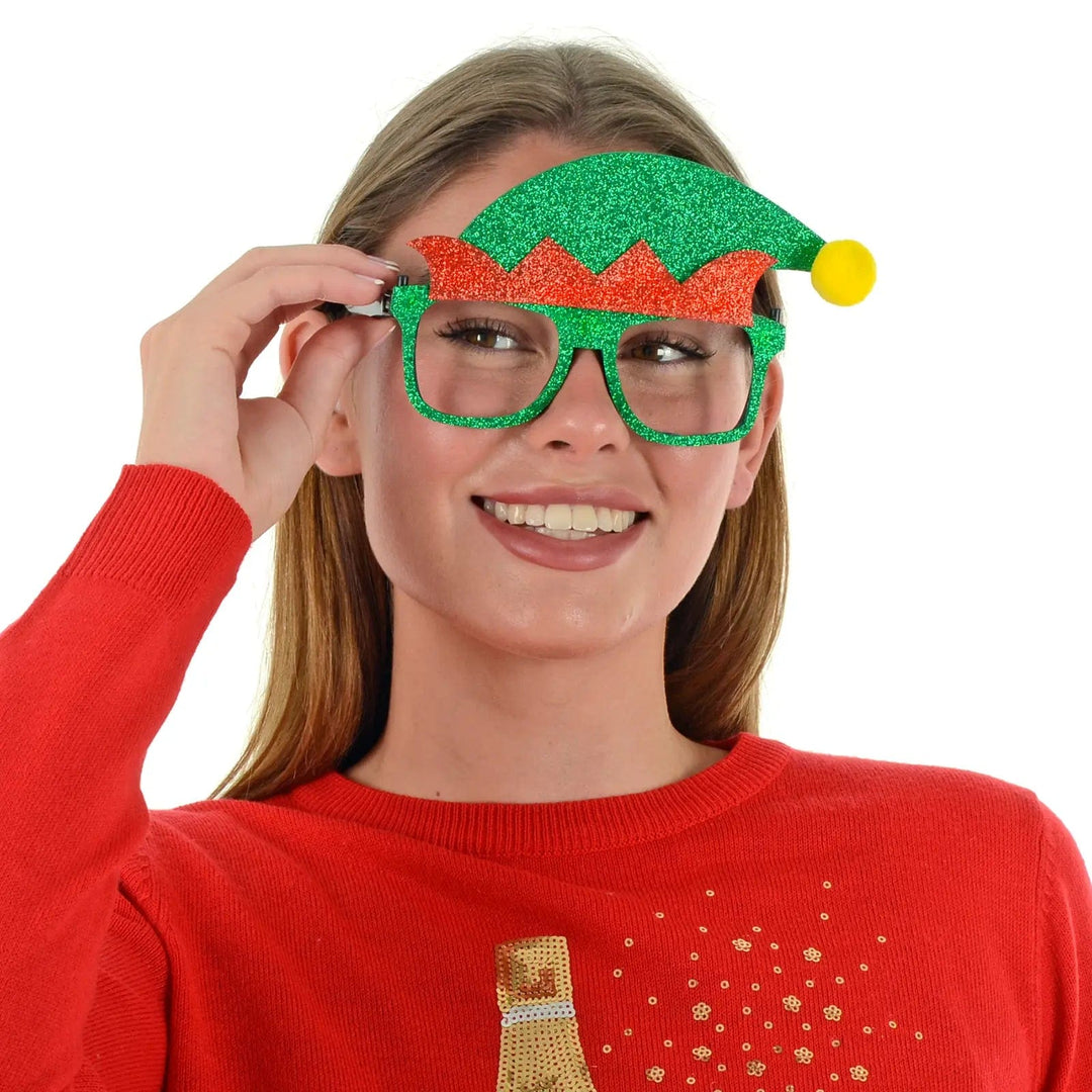 Young lady wearing a pair of Christmas Elf novelty glasses with red and green glitter and a yellow pom pom