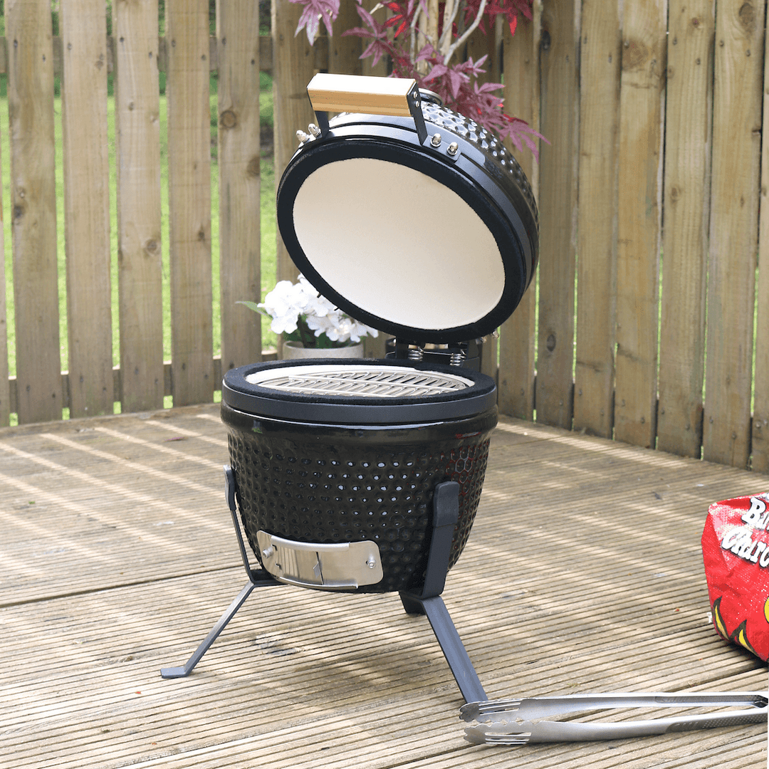 kamado egg bbq on patio space with lid raised to show stainless steel grill