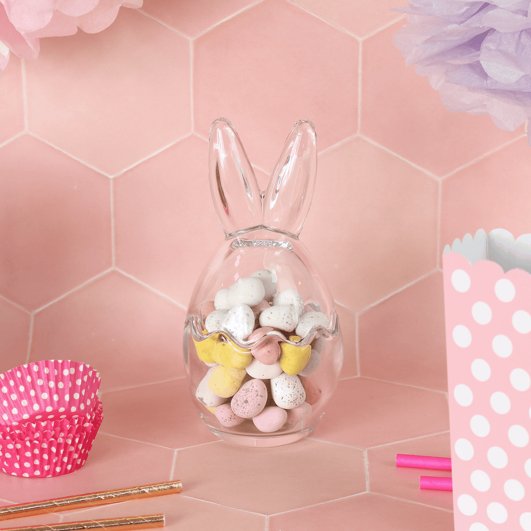 medium sized bunny ears storage jar on pink background filled with mini eggs with cupcake cases and boxes to the side