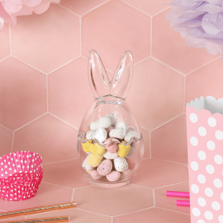 medium sized bunny ears storage jar on pink background filled with mini eggs with cupcake cases and boxes to the side