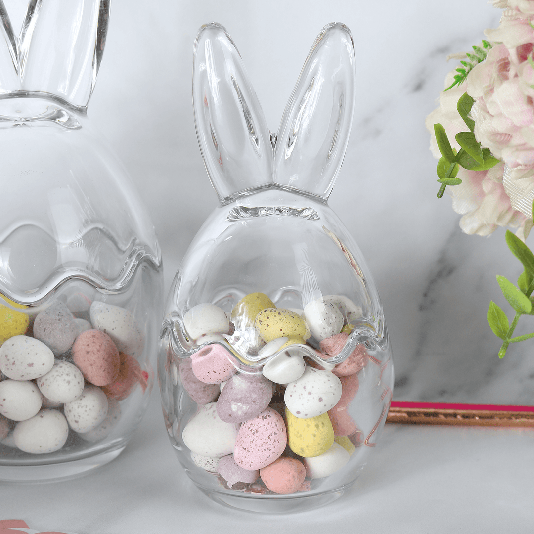 close up of medium sized bunny ears storage jar on marble counter filled with yellow, pink and white mini egg treats