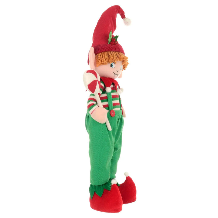 Side view of Christmas Boy elf Christmas figure standing in green, red and white fabric clothing