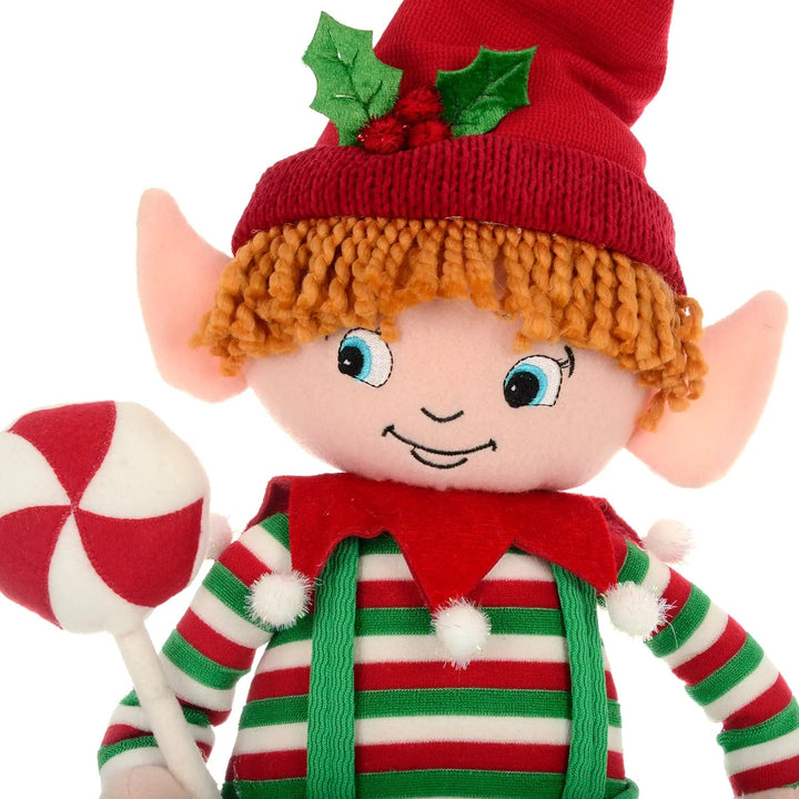 Close up the face of a Christmas Boy Elf figure with green, red and white striped jumper and ginger hair