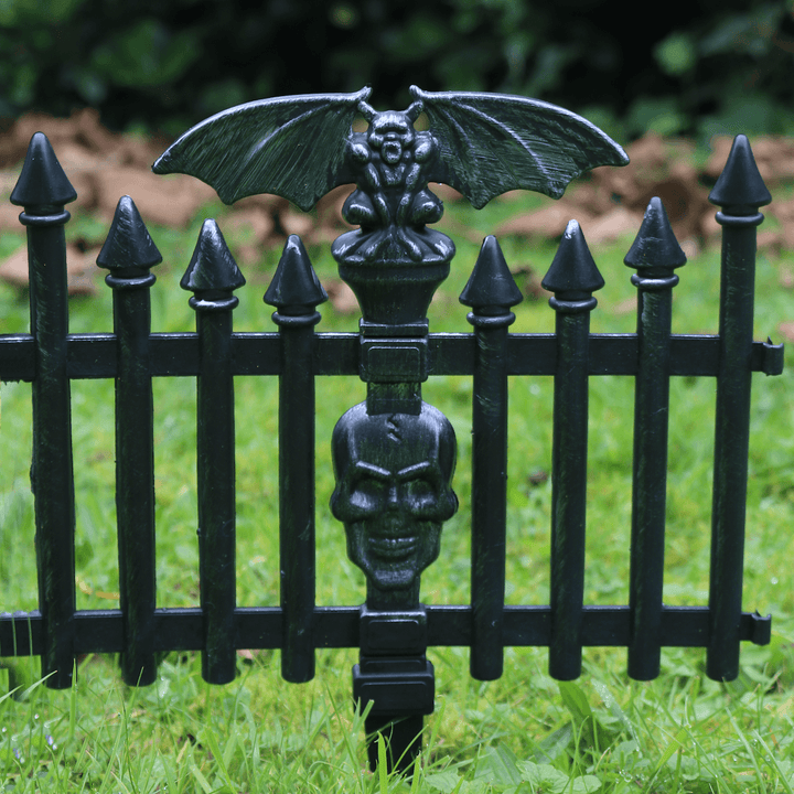 detail shot of graveyard piece secured in ground with brown leaves and trees in the background