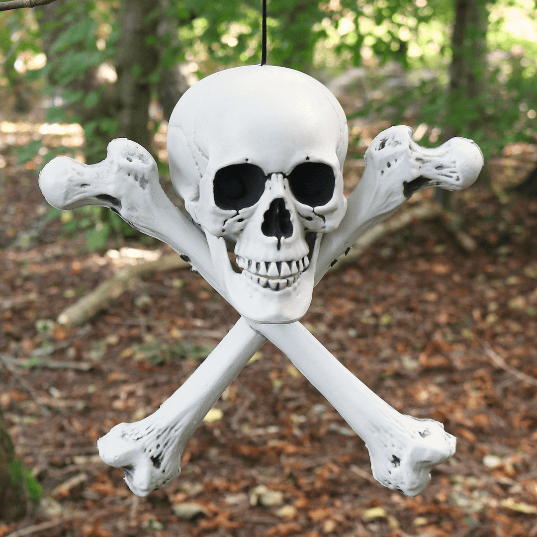 skull and crossbones decoration hanging in spooky forest setting