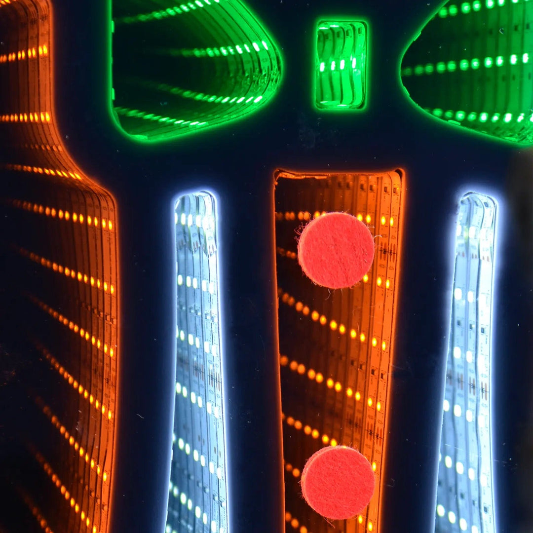 Close up of orange green and cool white LED lights on an infinity mirror Christmas decoration