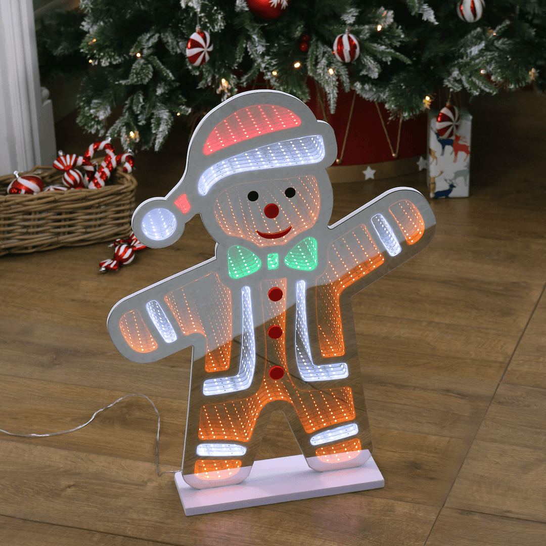 gingerbread man infinity light in front of christmas tree with decorations in basket to the side
